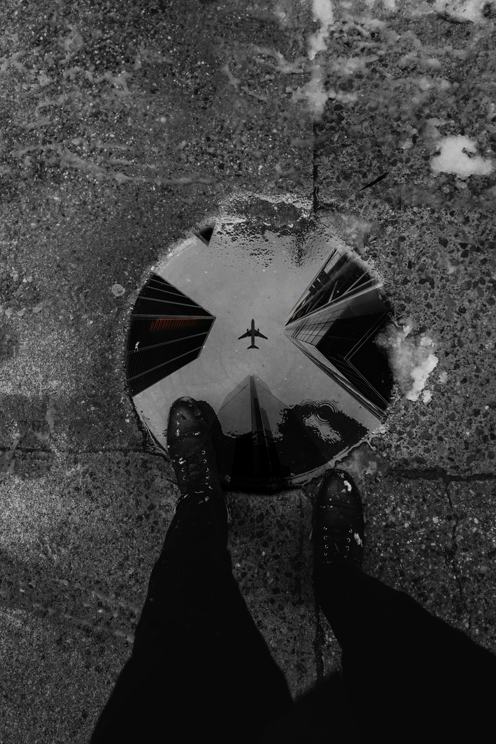 person in black pants and black shoes standing on black and white round hole