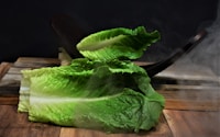 green leaf vegetable on brown wooden table