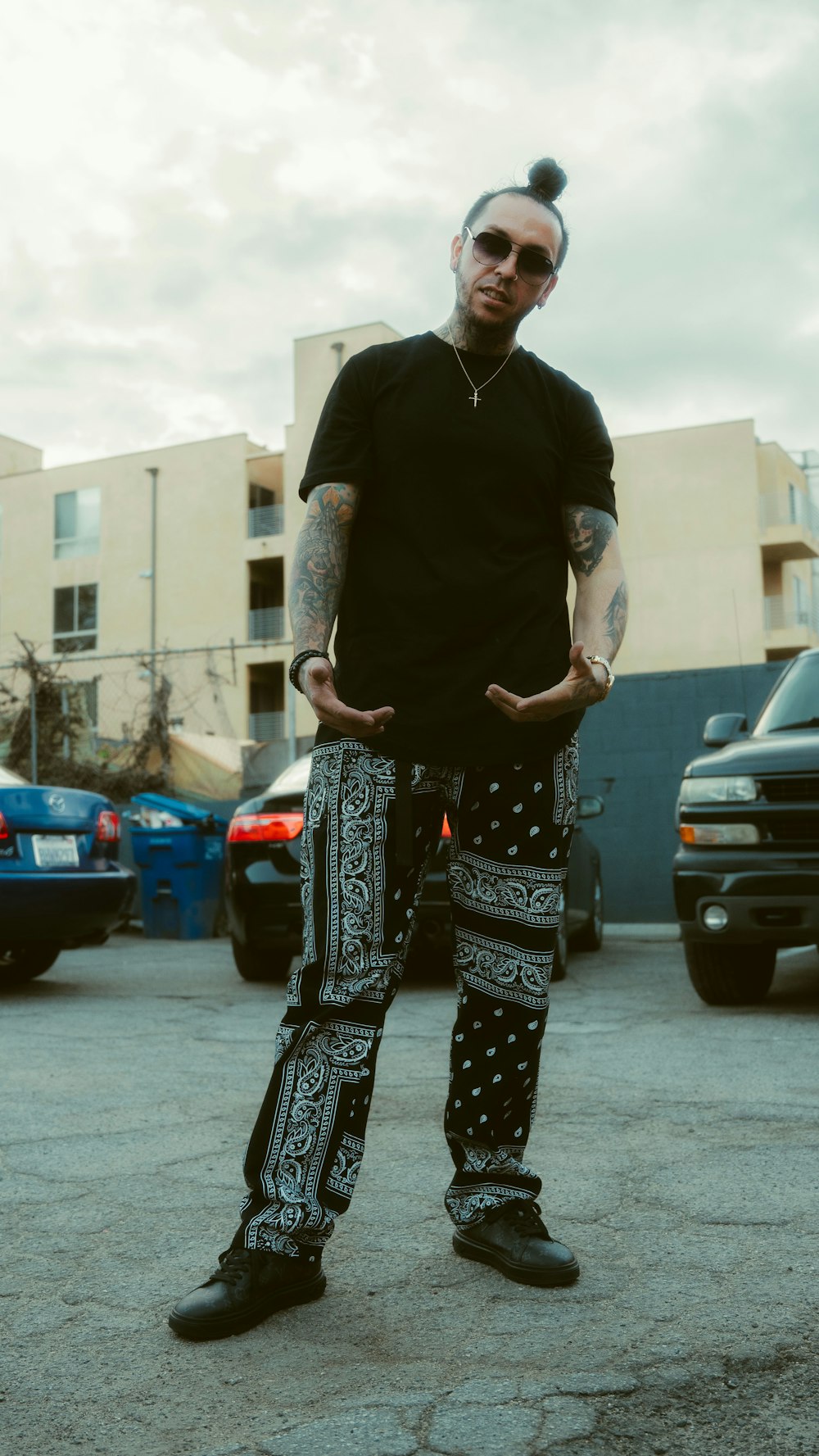 woman in black long sleeve shirt and black and white pants standing on gray concrete floor