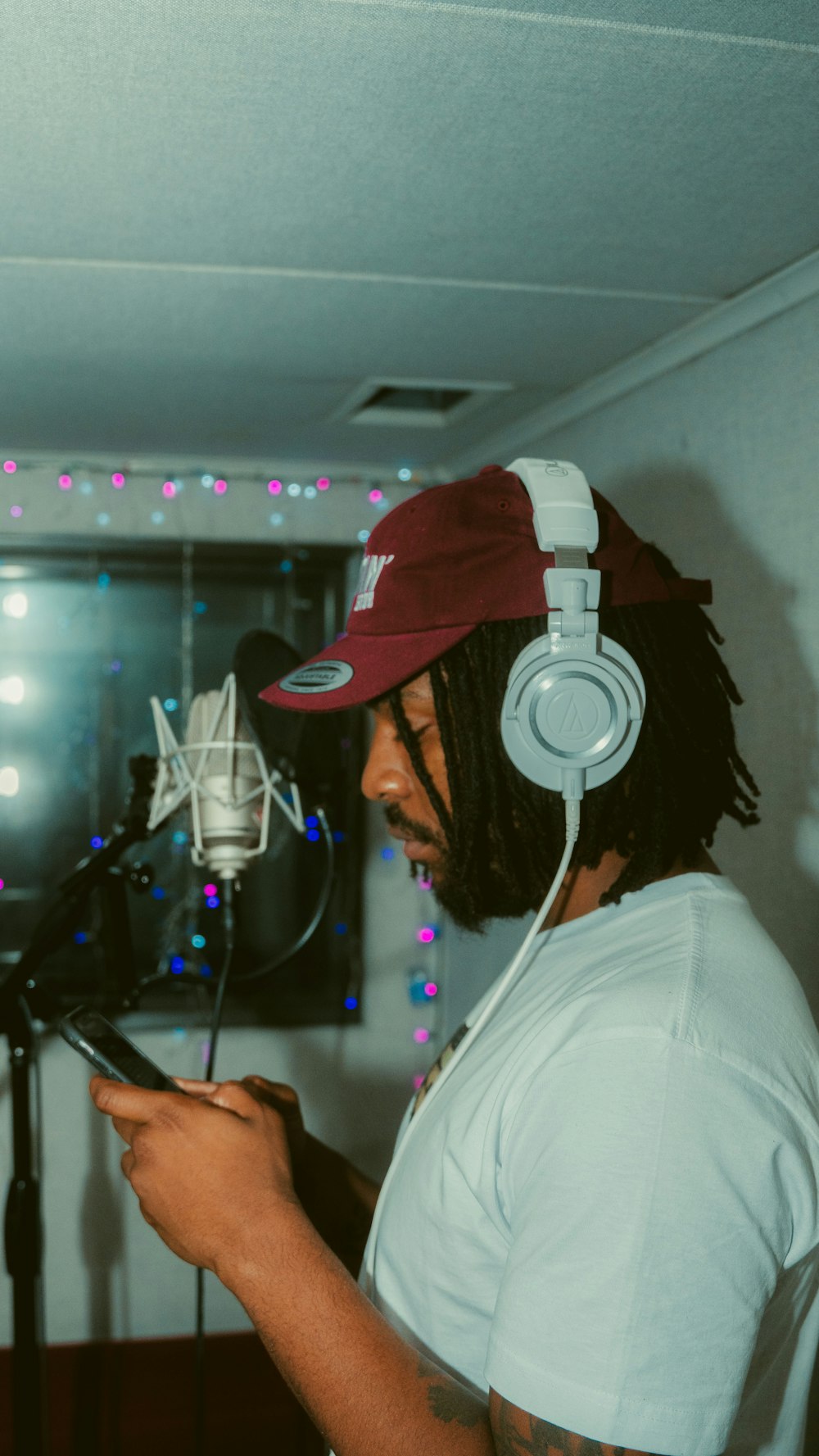 man in white shirt wearing red cap and headphones