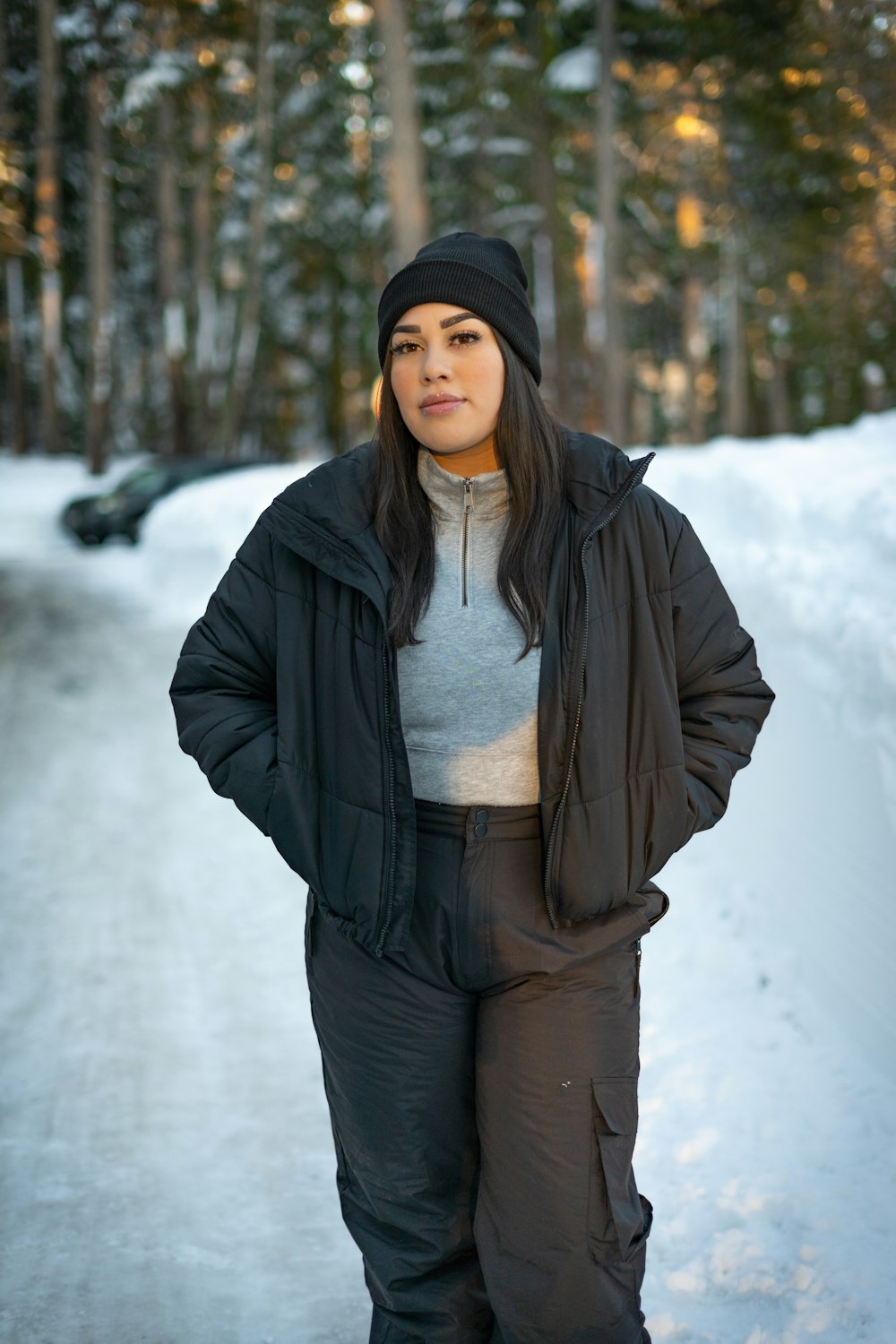 a woman standing on a snow covered road