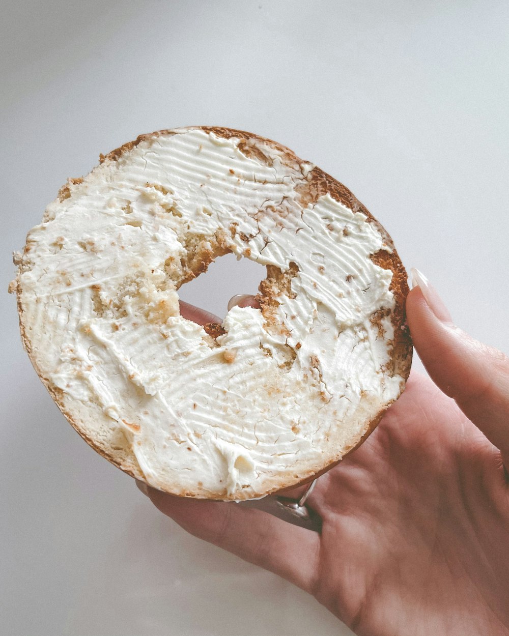 persona che tiene il pane bianco con la crema bianca