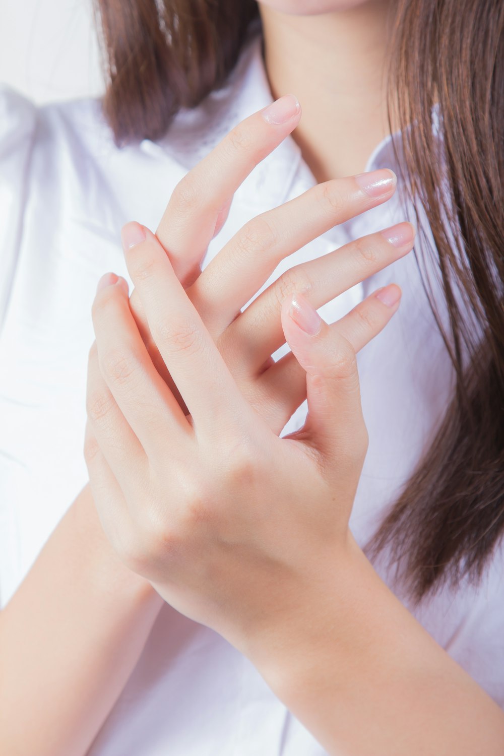 Frau im weißen Hemd bedeckt ihr Gesicht mit der Hand