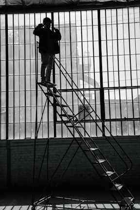 Dynamic shot of a technician dusting high shelves in a bright commercial space.