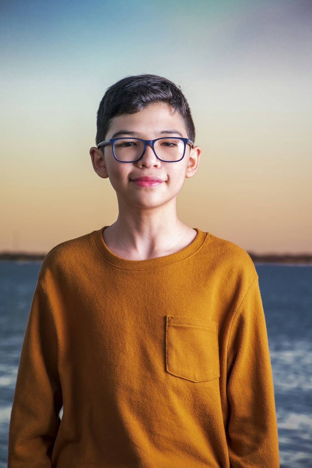 boy in brown crew neck sweater wearing black framed eyeglasses