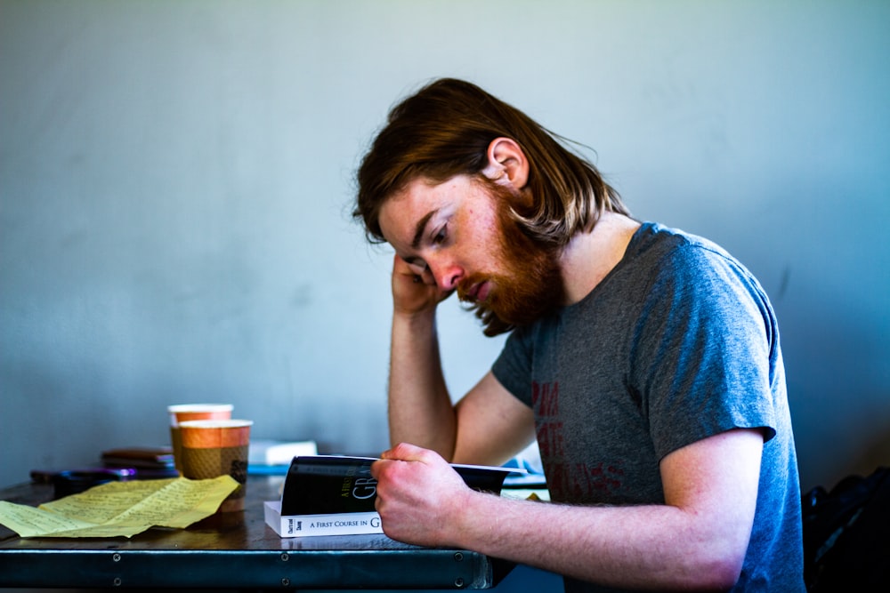 woman in blue shirt sitting by the table