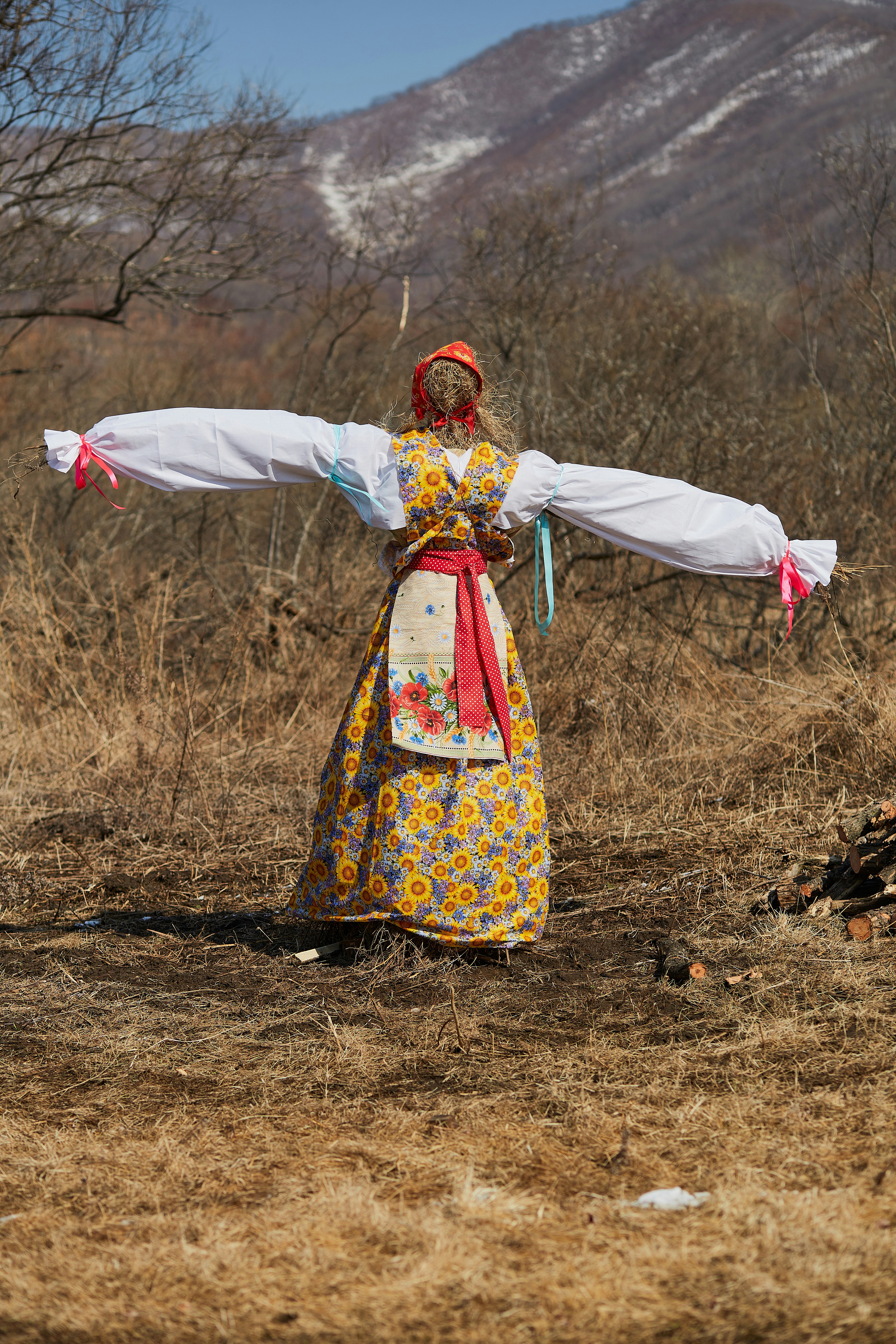 woman in white red and yellow floral dress holding white textile