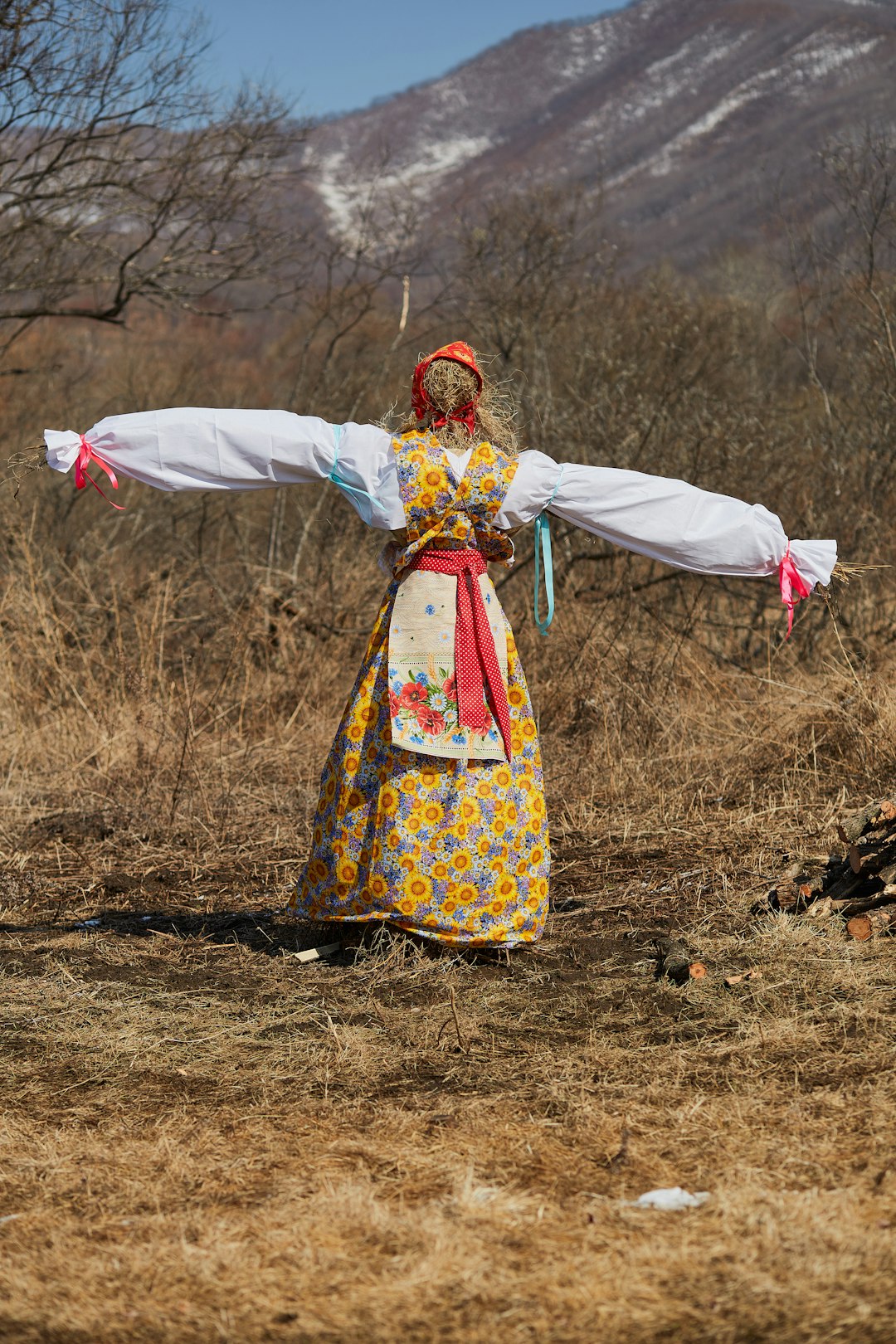 woman in white red and yellow floral dress holding white textile