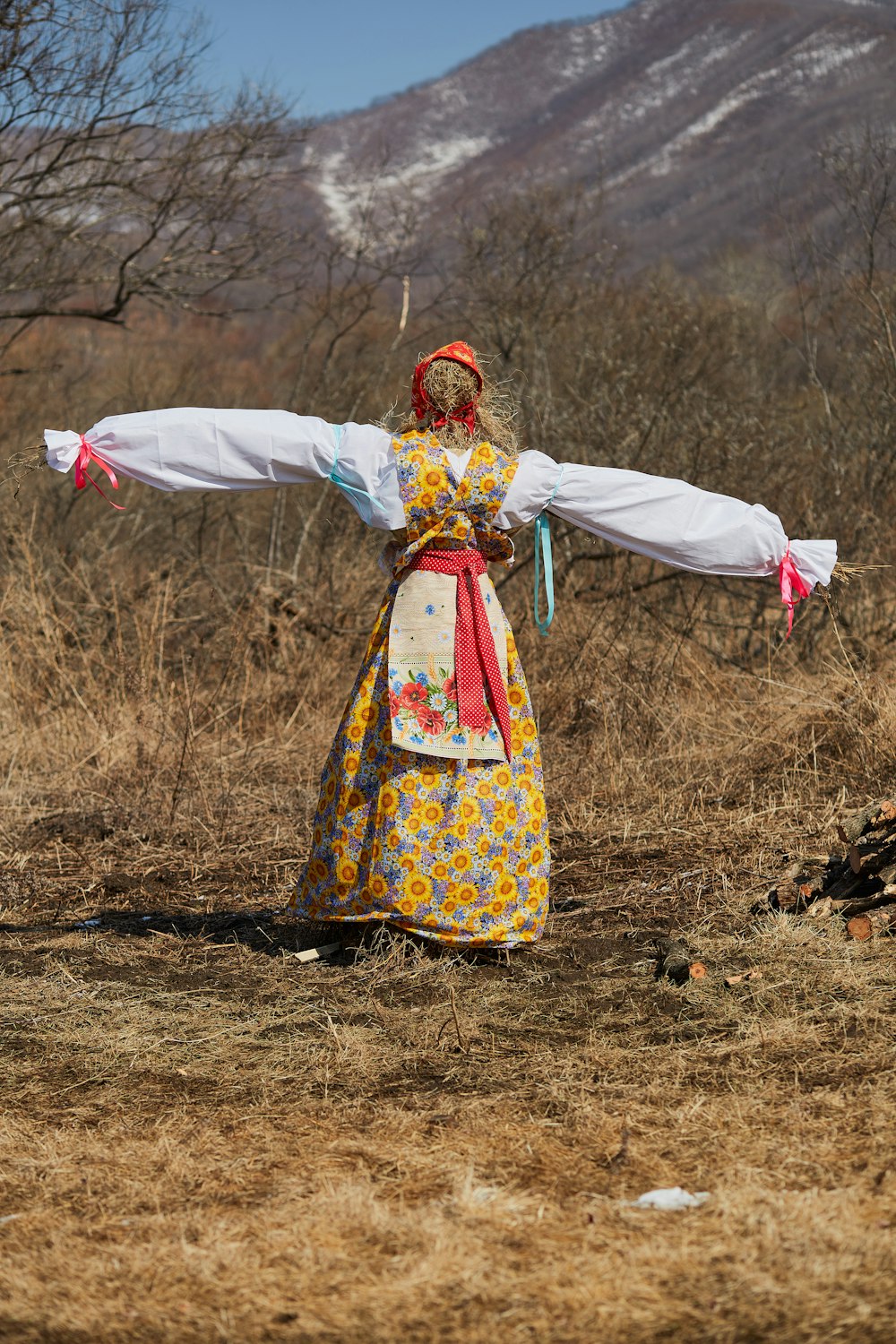 woman in white red and yellow floral dress holding white textile