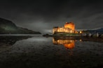 brown concrete castle on body of water