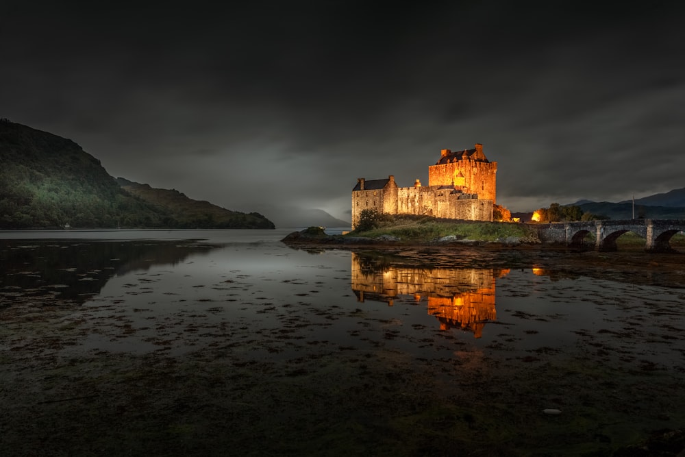 brown concrete castle on body of water