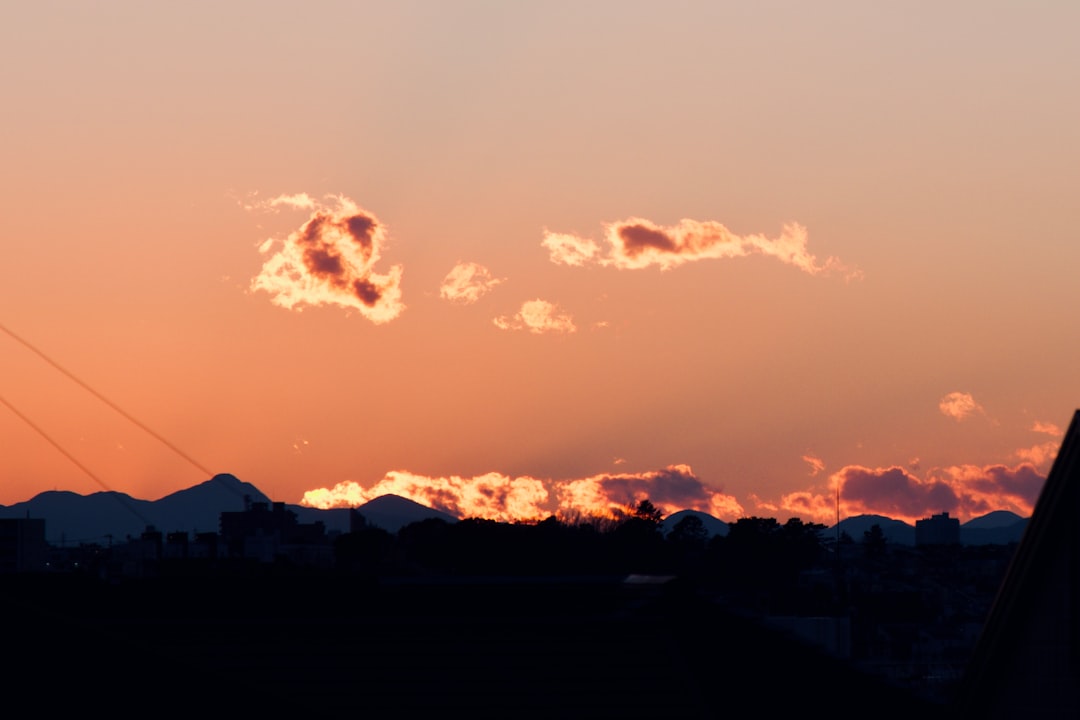 silhouette of mountain under cloudy sky during sunset