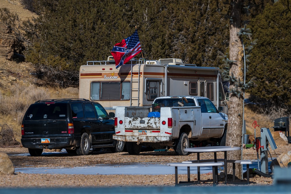 Camionnette blanche à cabine double garée à côté d’une fourgonnette blanche et bleue pendant la journée