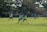 A diverse group of young players practicing soccer on a sunny field.
