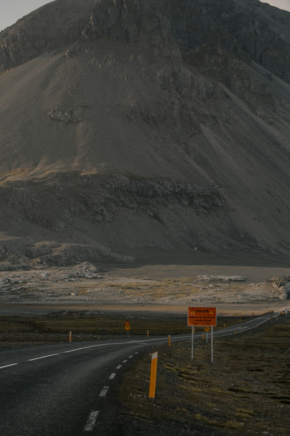 gray asphalt road near gray mountain during daytime
