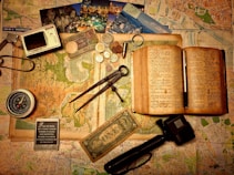black and silver scissors beside brown book and black and silver scissors