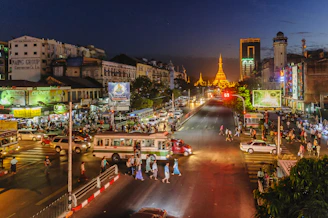 A vibrant street billboard in Phnom Penh glowing with bright orange hues at dusk.