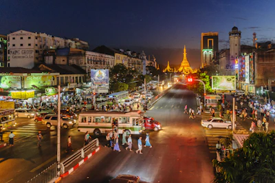 Cityscape of Phnom Penh showcasing diverse advertising billboards lit up at dusk.