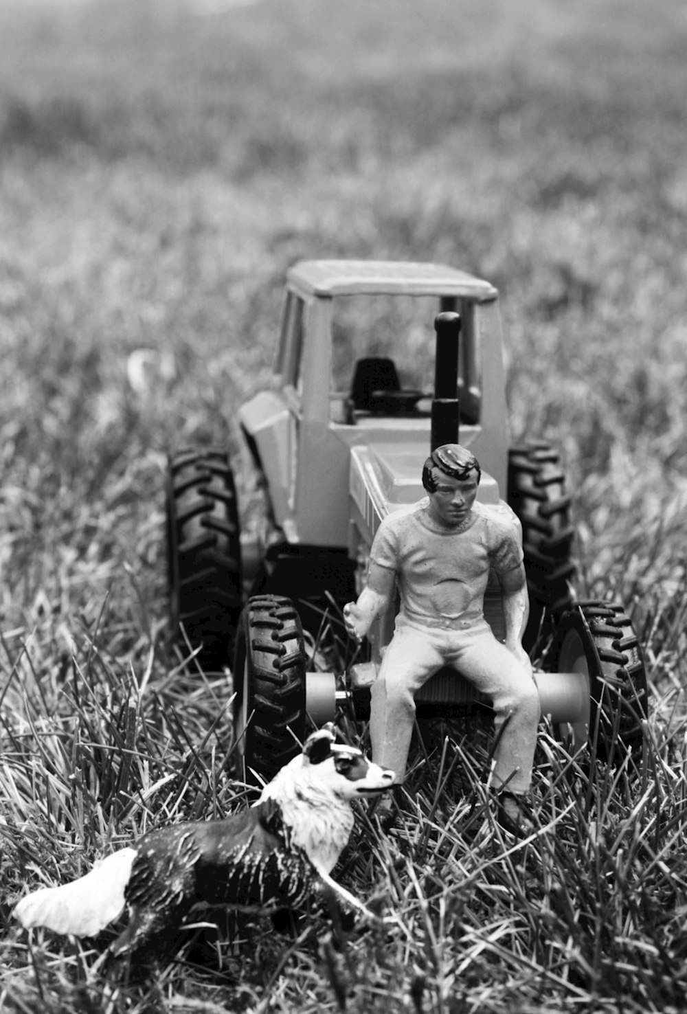 grayscale photo of man sitting on tractor