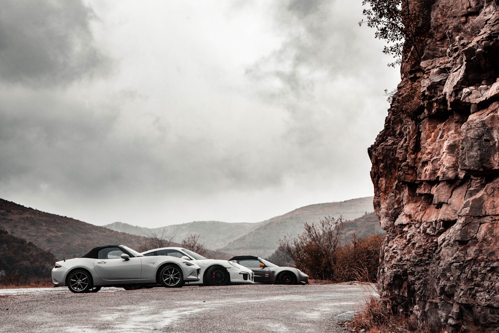 white coupe on road near mountain during daytime