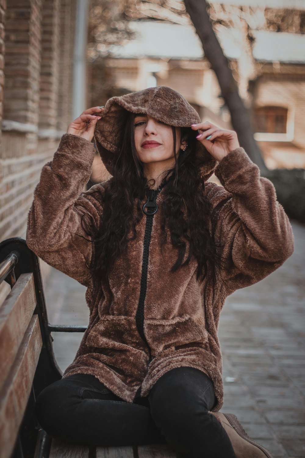 a woman sitting on top of a wooden bench