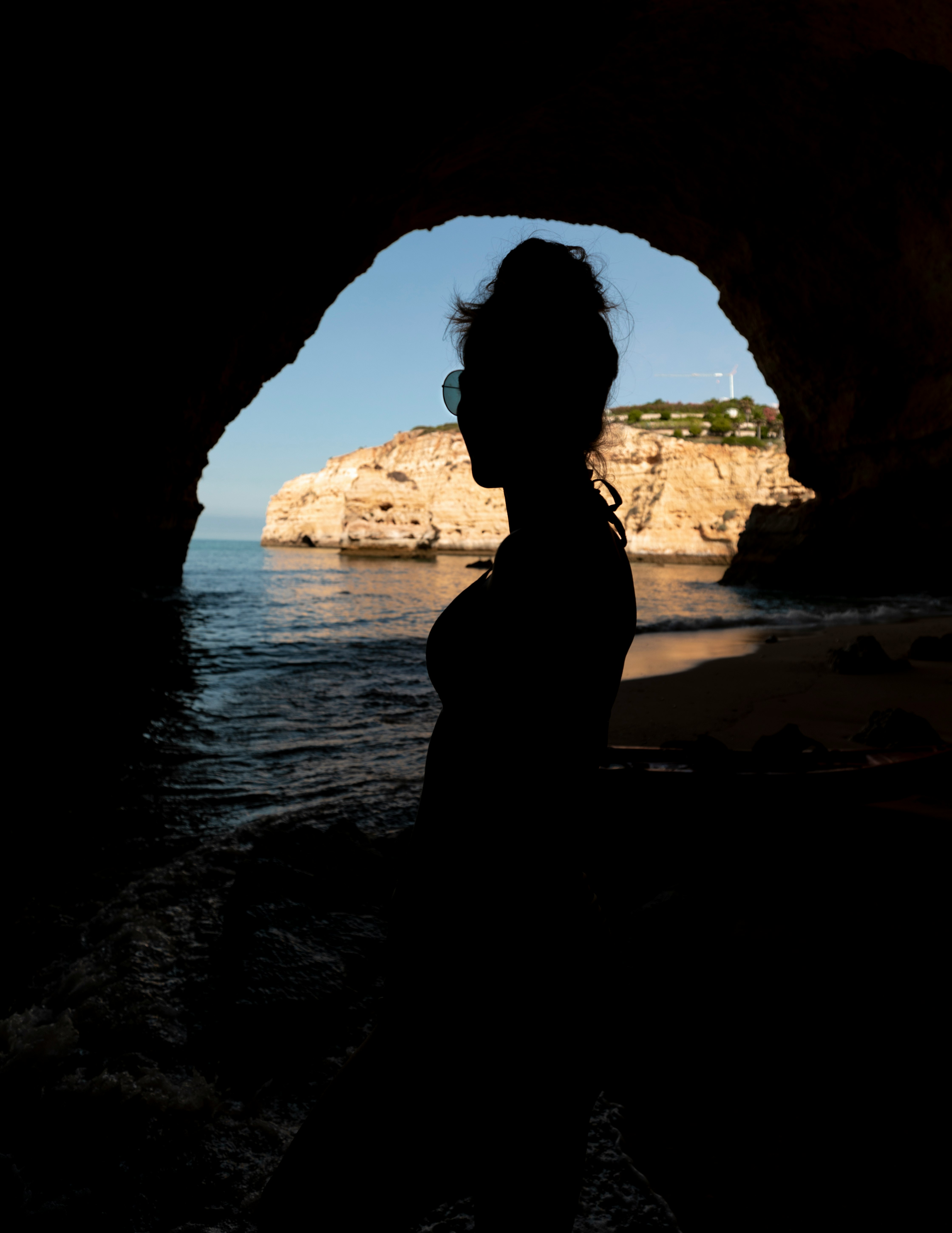 silhouette of woman standing in cave