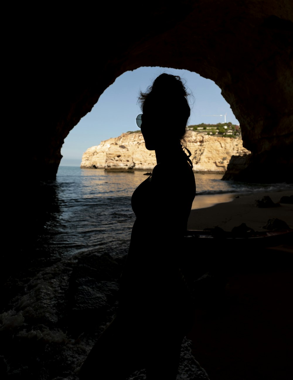 silhouette of woman standing in cave