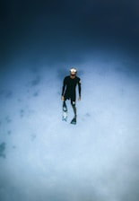man in black jacket and black pants standing on snow covered ground
