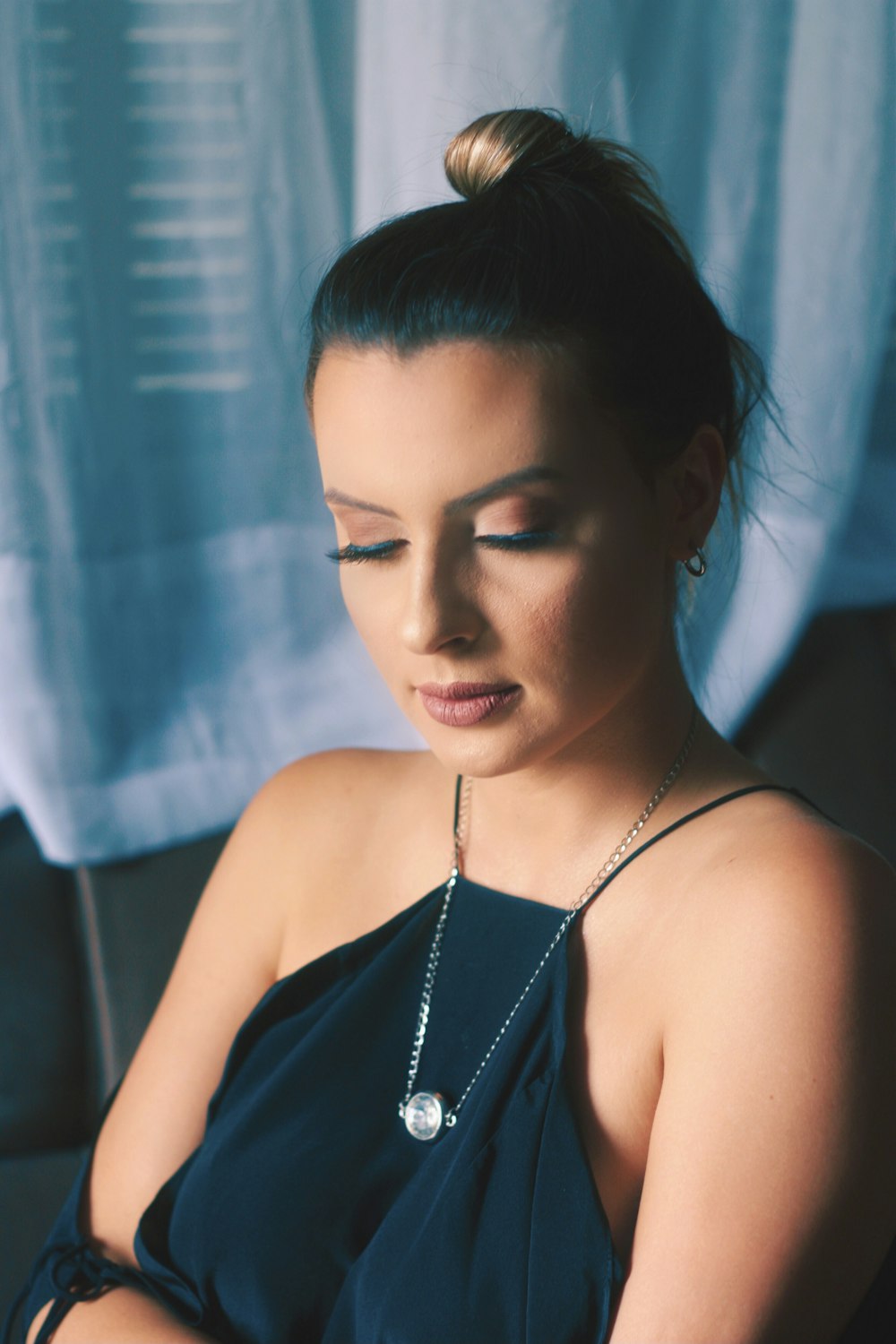 woman in black spaghetti strap top wearing silver necklace