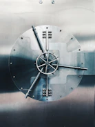 Close-up of a sleek black vault door with subtle gold accents reflecting light.