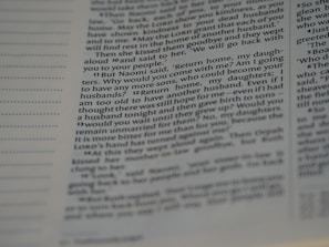 A close-up view of a page from a book, featuring text in a column format with a line of dots on the left side. The text seems to be a passage from a religious or literary document, possibly discussing the story of Naomi and her daughters.