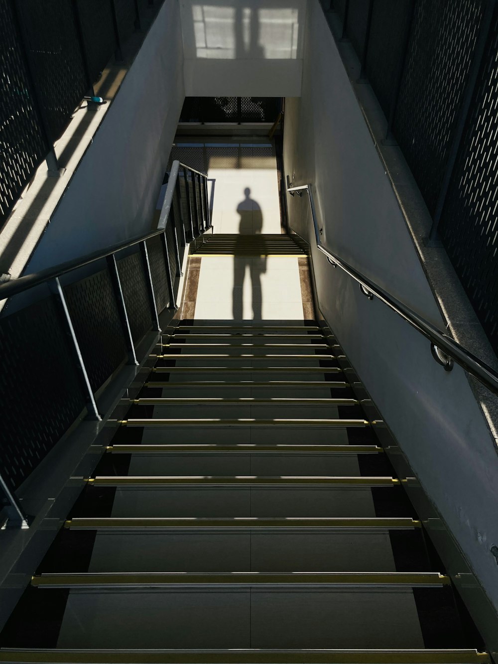 black and white staircase with stainless steel railings