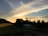 Sunset view over a forested landscape surrounding a charming rural house.