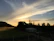Sunset view over a forested landscape surrounding a charming rural house.