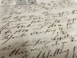 Close-up of an old, delicate masonic constitution page, displaying intricate typography and vintage paper texture.