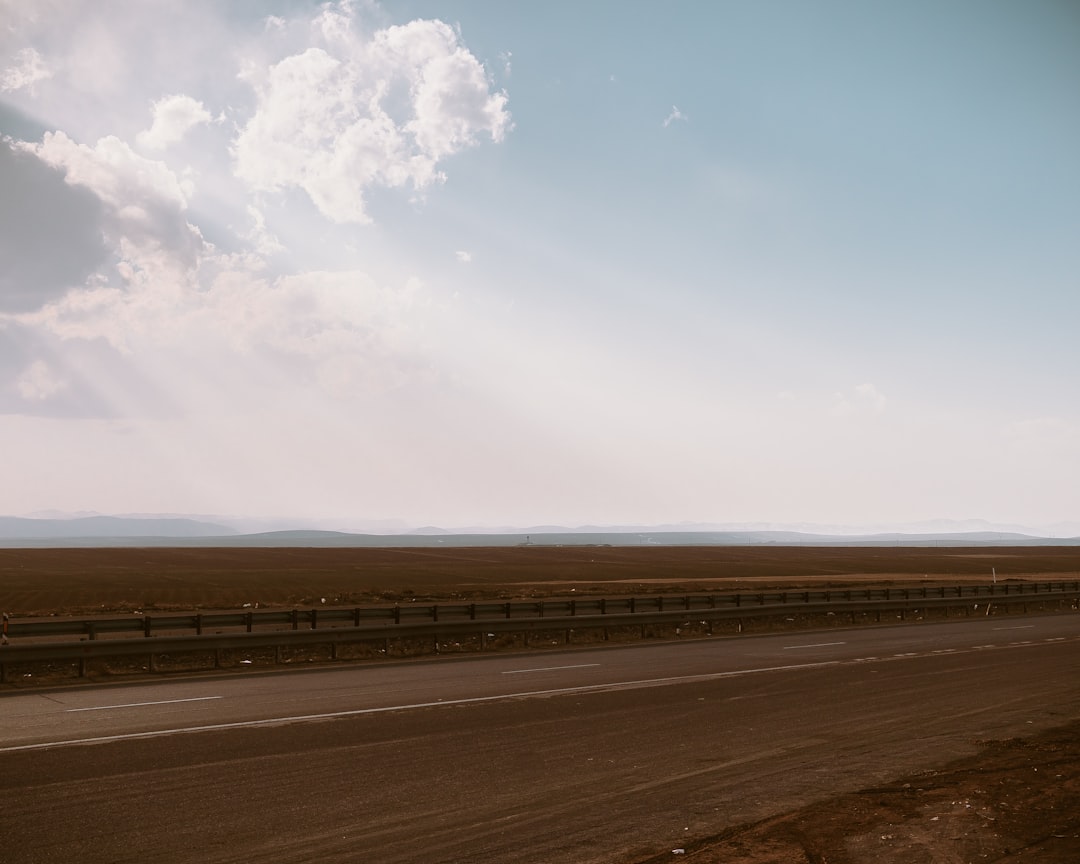 brown asphalt road under blue sky during daytime