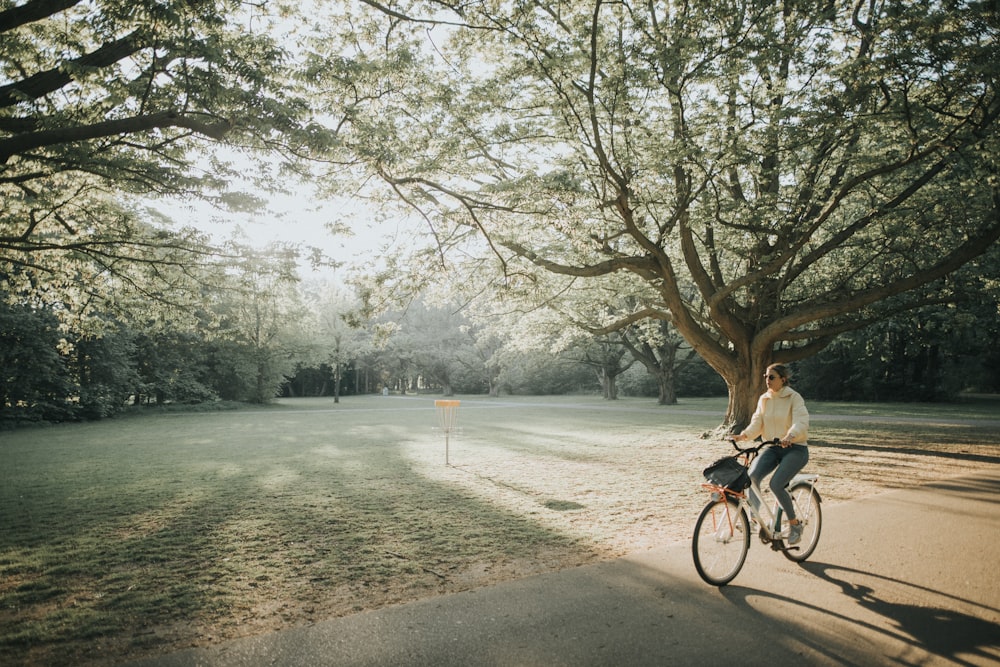 man in black jacket riding bicycle on road during daytime