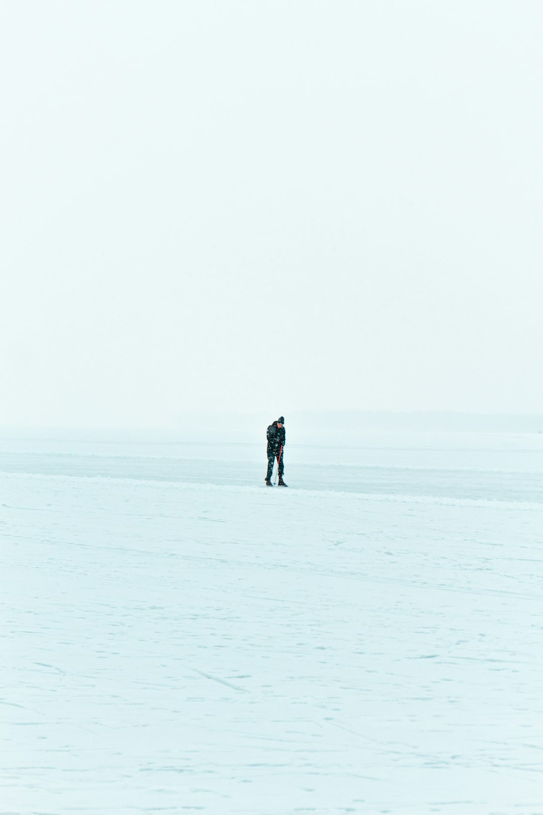 person in black jacket walking on snow covered field during daytime