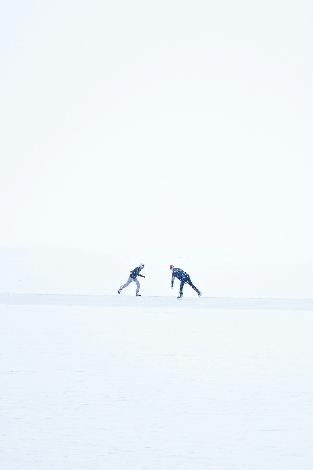 2 person walking on snow covered field during daytime