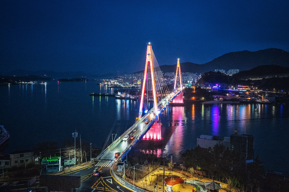 lighted bridge over body of water during night time