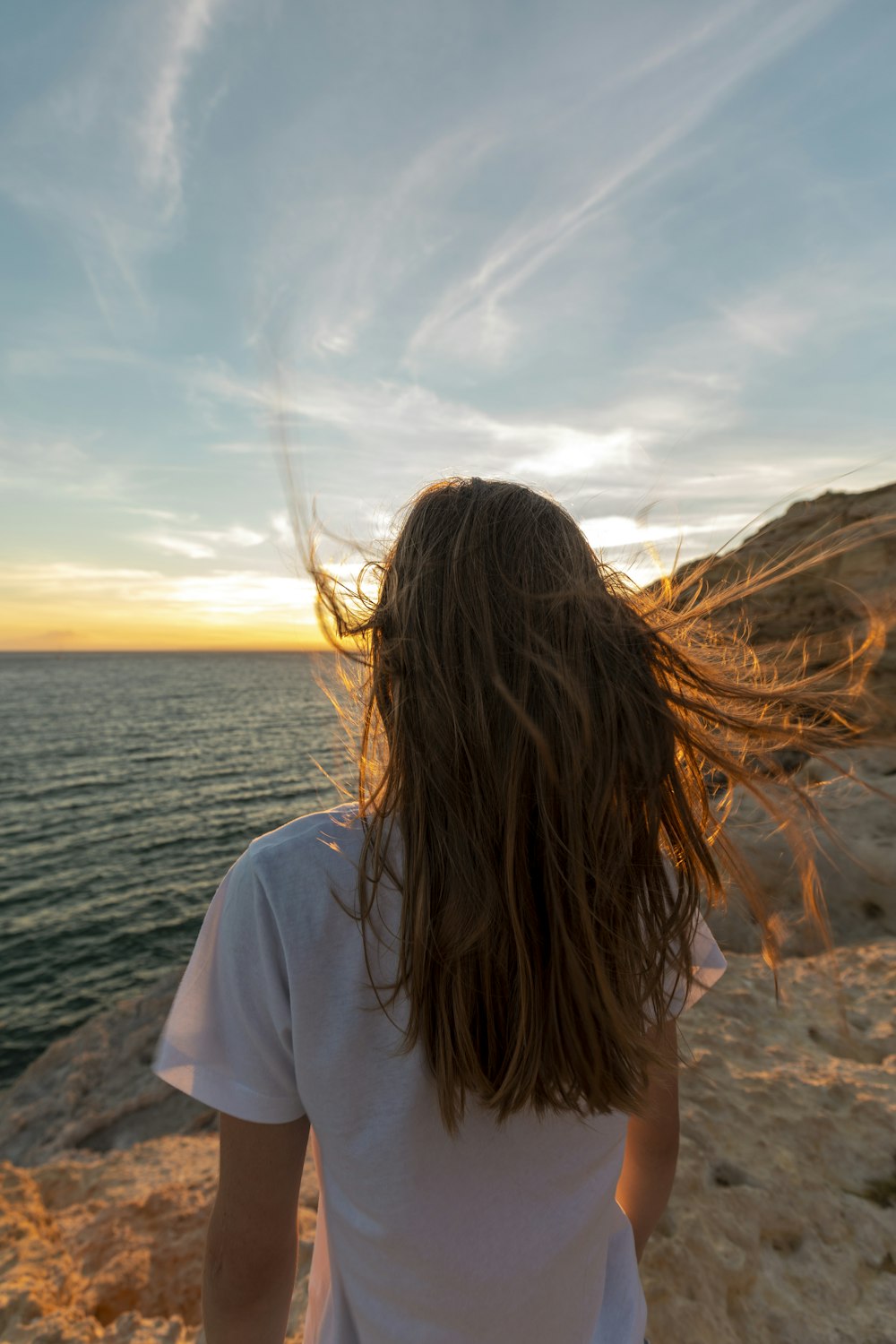 woman in white shirt standing on beach during daytime