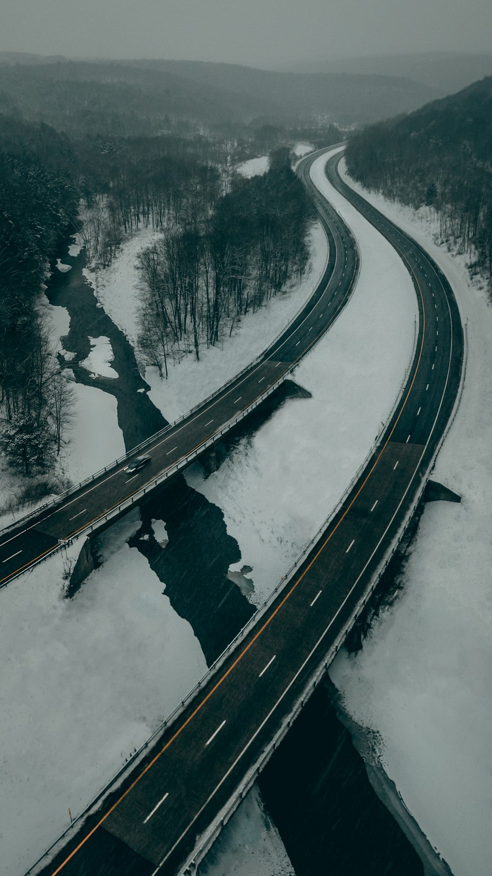 schwarze Asphaltstraße mit Schnee bedeckt