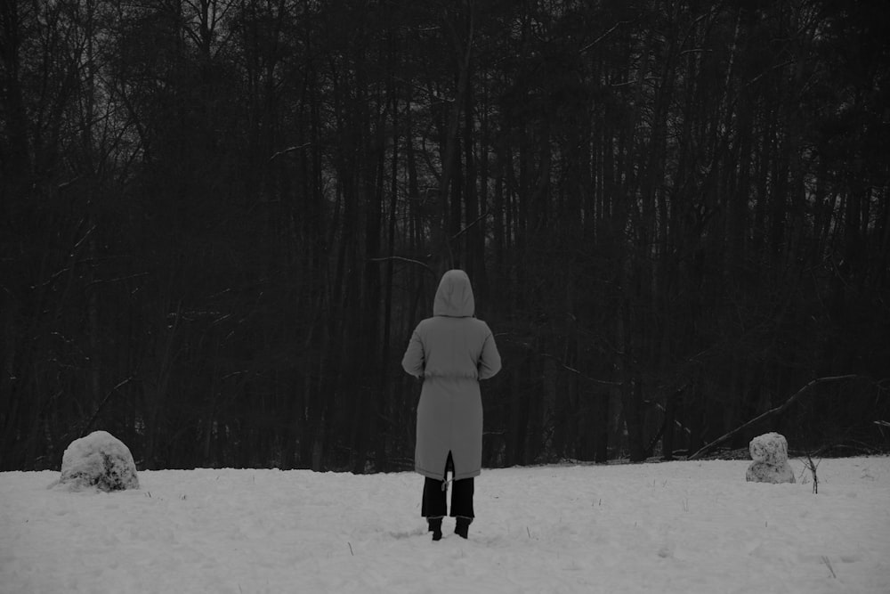 person in gray hoodie standing on snow covered ground