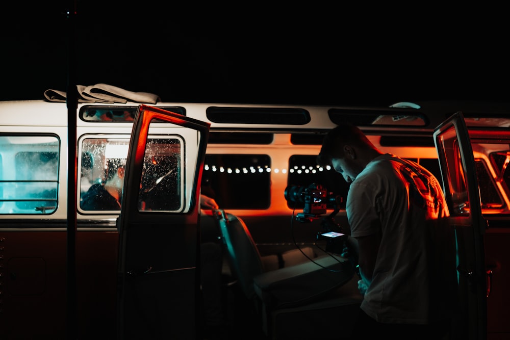 man in orange shirt driving car during night time