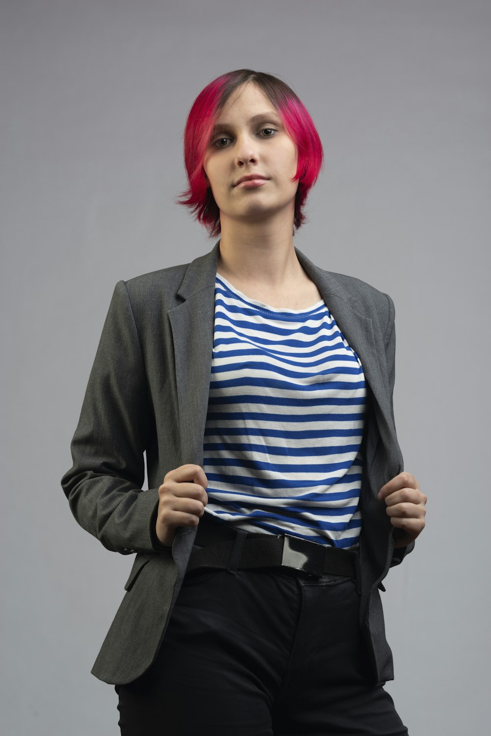 Una donna con i capelli rosa e una camicia a righe