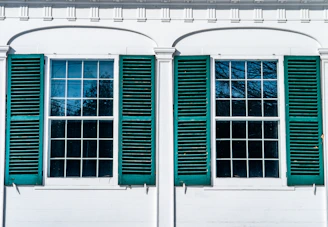 Exterior shot of a house with gleaming windows reflecting the blue sky.