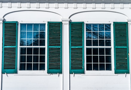 Close-up of sparkling clean residential windows reflecting the blue sky and greenery.