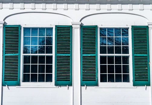 Exterior shot of a house with gleaming windows reflecting the blue sky.
