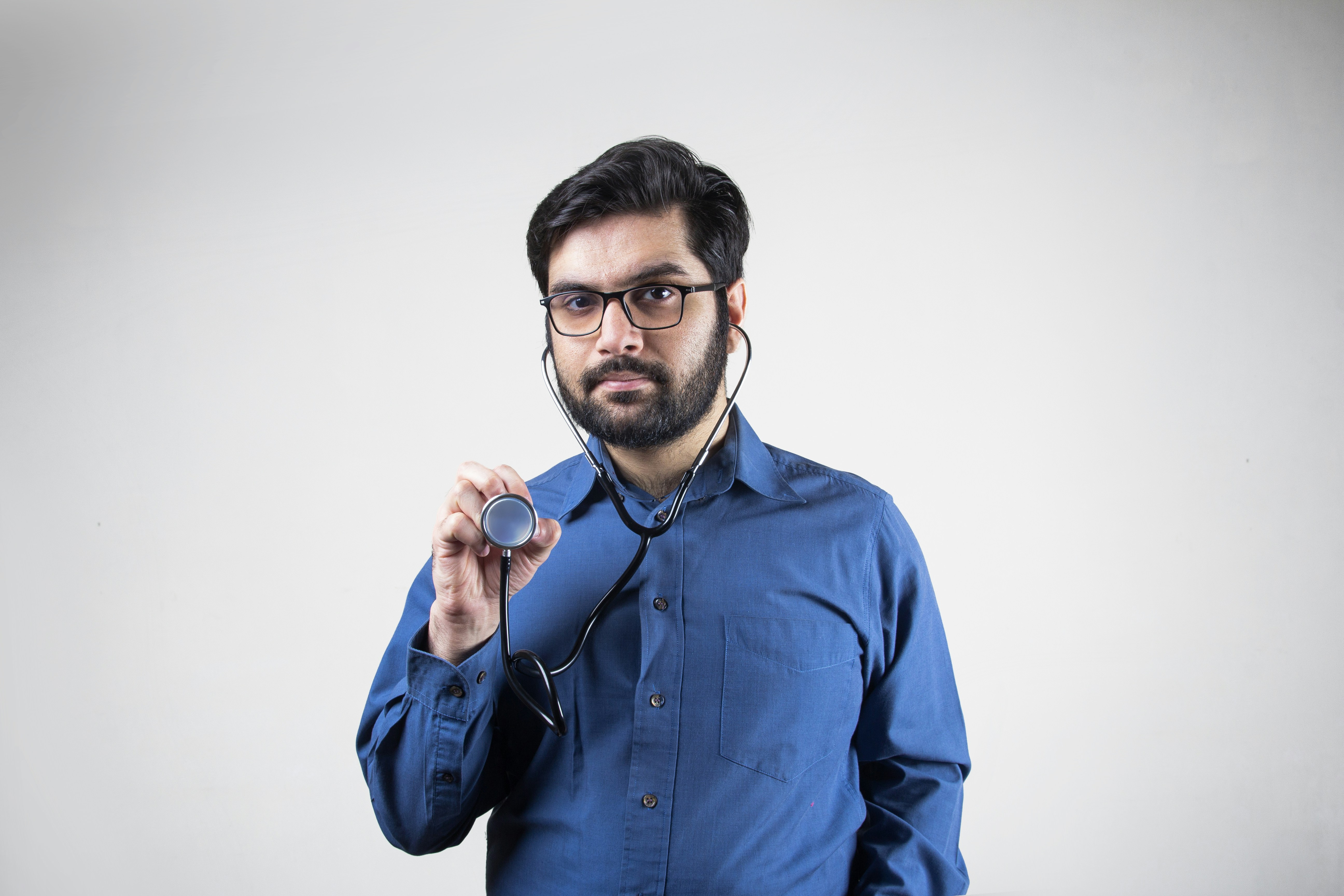 A doctor wearing stethoscope pointing in front