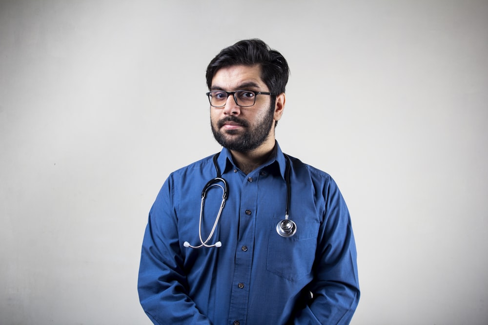 hombre con camisa de vestir azul con gafas de montura negra